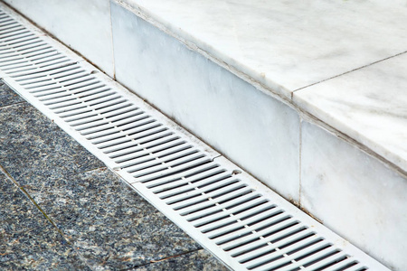 关闭住宅家的雨水沟,堵塞了干燥的落叶. 有干棕色叶子的阴沟和排水沟.