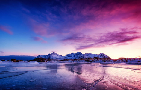 冻结湖面上的山脊和冰。 挪威洛夫顿群岛的自然景观。 日落时的水和山。