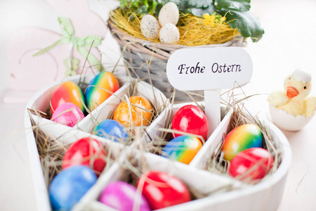 彩色复活节彩蛋在老式彩绘的木制背景上。 德语课文快乐复活节。