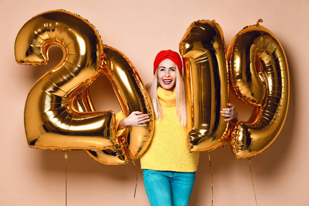 妇女庆祝新年圣诞晚会快乐笑黄色毛衣衬衫与2019年黄金气球