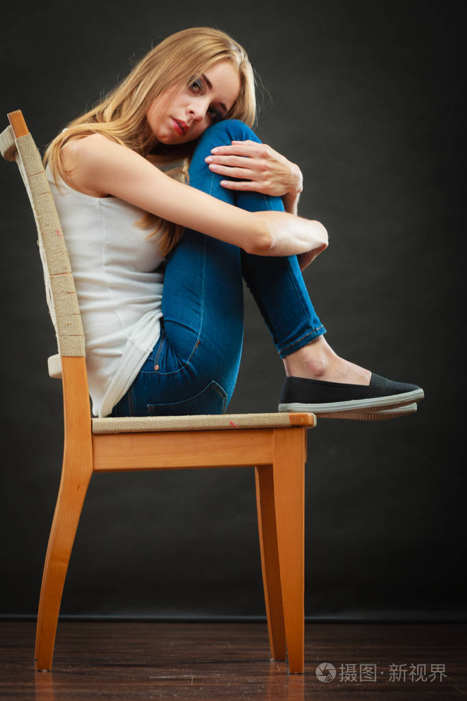 孤独消极情感概念坐在椅子上的年轻悲伤孤独的女人