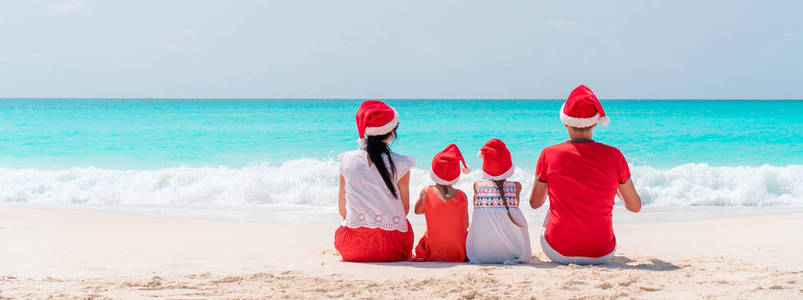 在加勒比海海滩庆祝圣诞假期的快乐家庭