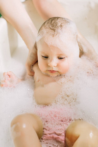 卫生和照顾幼儿. 可爱的洗澡宝宝,头发上有肥皂泡照片