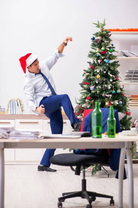 年轻英俊的员工在工作场所庆祝圣诞节