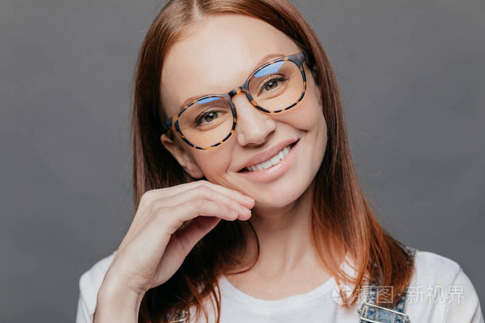 欧式美女模特近照,微笑温柔,乐于接受老板好评,戴眼镜,手贴脸,隔着灰
