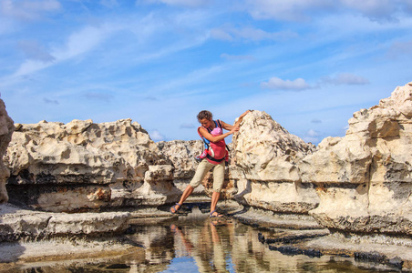 带着小孩的快乐母亲正沿着地中海尖锐的珊瑚海岸散步