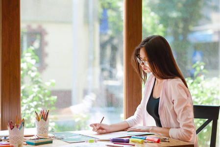 女艺术家坐着, 拿着铅笔, 画画照片