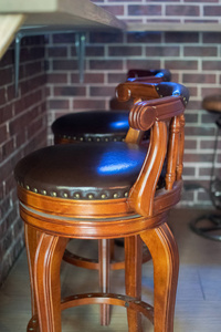 咖啡厅酒吧内部木制酒吧和酒吧椅子。酒吧柜台附近的棕色皮椅。