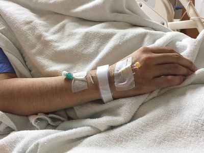 一个病人躺在床上用毯子照片