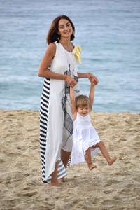 妈妈和她的小女儿在海滩上的幸福