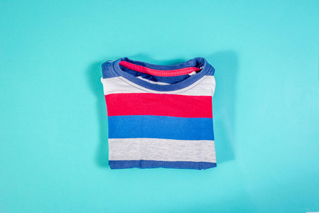 s longsleeved Tshirt. A shirt with red and blue stripes lies o