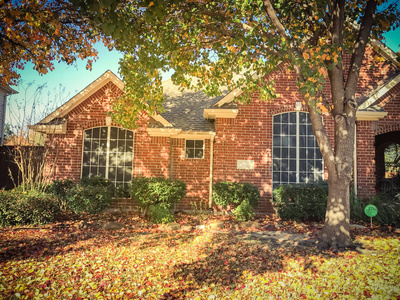 复古色调美丽的单身家庭住宅在秋季靠近达拉斯德克萨斯美国。 布拉福德梨卡莱丽梨厚厚的地毯，树上的叶子和地上阳光明媚的秋晨