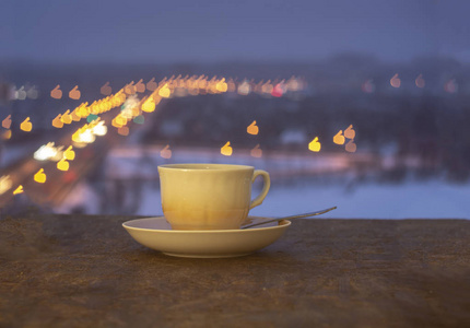 杯子和碟子有模糊的彩色背景。杯子站在一个碟子上，有一个五颜六色的波克。