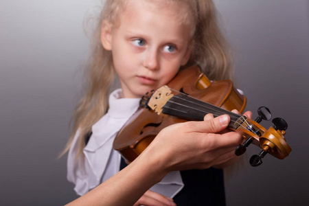 s hand helps a little girl to play the violin