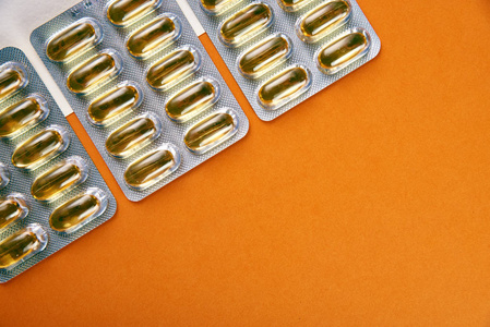 三包漂亮的半透明药丸在白色背景上隔离. 鱼油饱和欧米茄3在胶囊中.