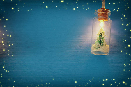 马斯顿罐子里的圣诞树照片，在木蓝色背景下的花环上发光