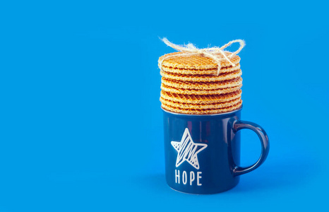 堆积的华夫饼荷兰华夫饼称为蓝色背景上的斯特罗帕菲尔,配有蓝色的茶