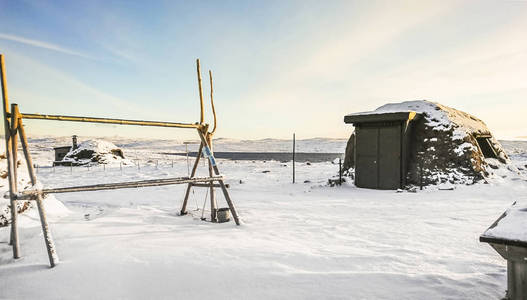 九月挪威北部美丽的雪景，地下有木屋和温暖的民族结构。
