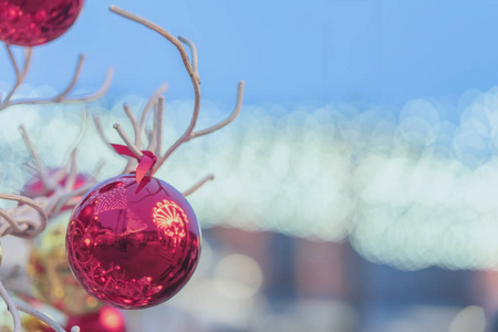 红色圣诞球，街道反射挂在装饰木制树户外。抽象节日背景，蓝色复制空间