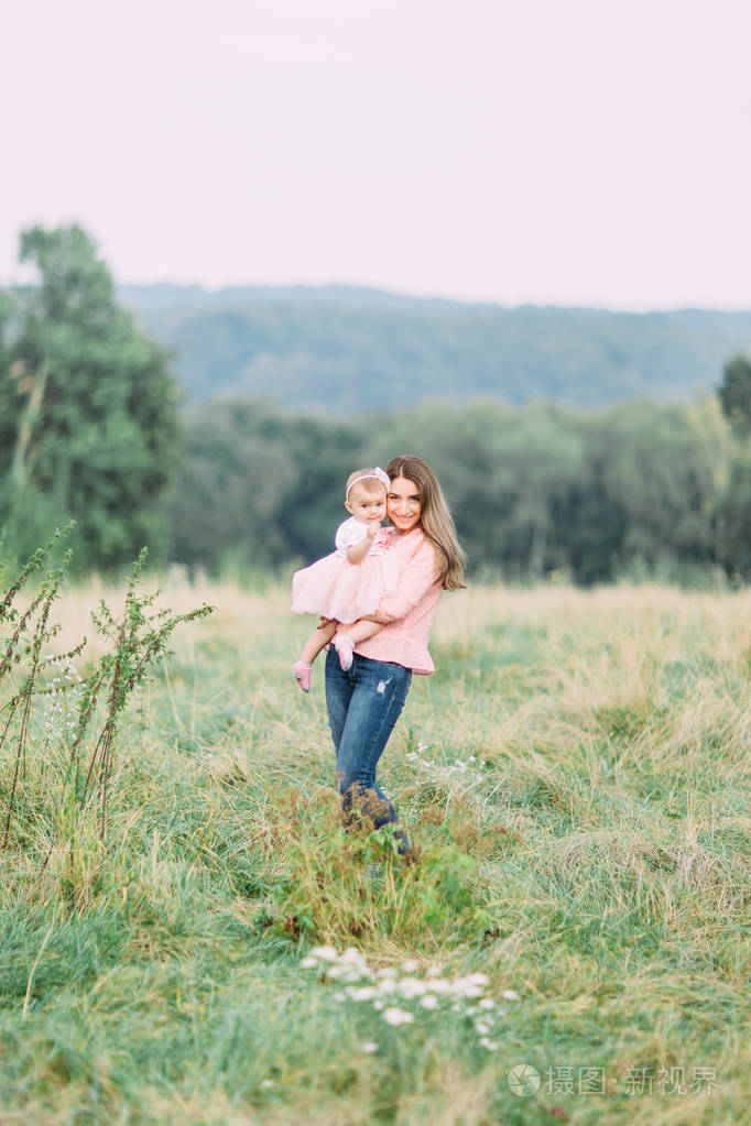 妈妈和小女儿在公园里一起玩. 幸福快乐的家庭.