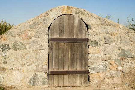 s a weathered wooden door in the rock wall