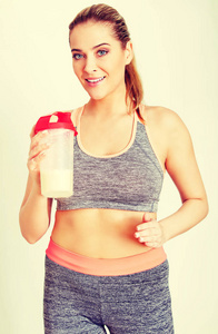 年轻的运动型女人与蛋白质摇瓶图片