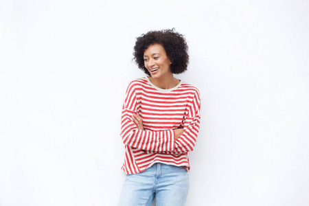 幸福的非洲裔美国妇女的肖像画，手臂交叉在白色墙壁上笑