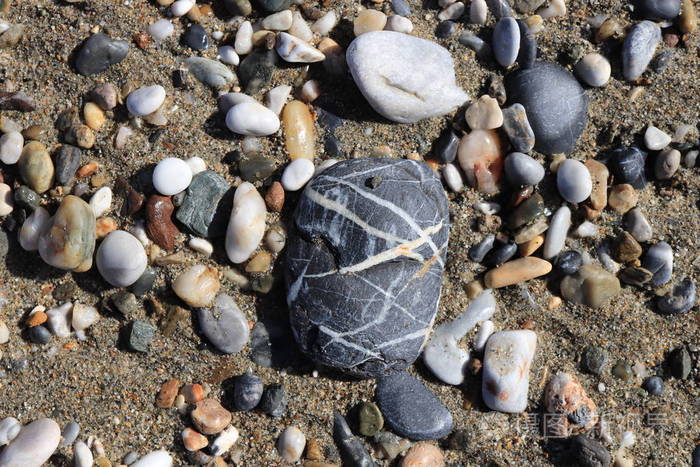 海滩石头表面。 有鹅卵石质地的海卵石。 海洋矿物美和谐。