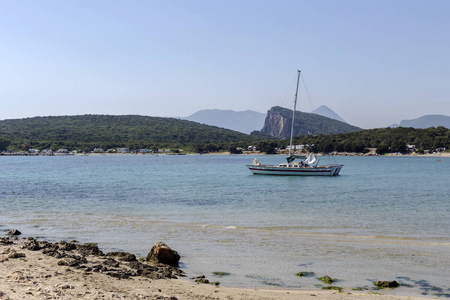 一艘白色游艇，帆停泊在海岸附近的开阔海域，在一个夏天阳光明媚的日子希腊埃皮鲁斯地区。