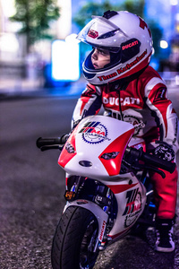 一个骑着玩具摩托车的孩子骑在街上