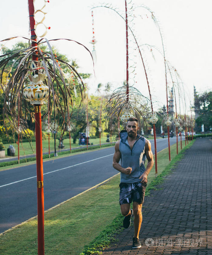 在亚洲日落时分强壮强壮的男人在路上奔跑