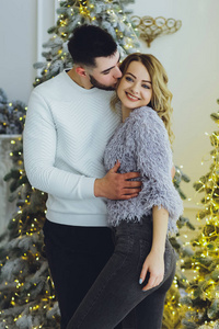 恋爱中的夫妻一个男人和一个女孩在圣诞树的背景上圣诞节背景