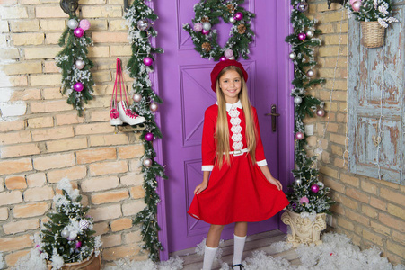 红色的圣诞节。穿着圣诞礼服的小女孩。时尚的小孩。小巧时尚的造型。小时尚达人在圣诞装饰。时尚女孩准备圣诞节庆祝活动