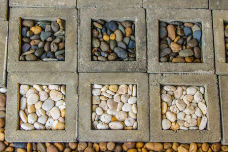 小光滑的水穿着白色,棕色和黑色的鹅卵石或石头,用于装饰和花园景观.