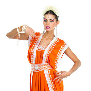 白种人黑发女人，穿着橙色印度民族服装的莎莉，在白种人的背景上的工作室