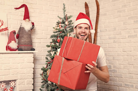 红帽的圣诞猛男带着包裹的礼物微笑
