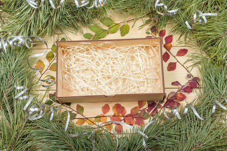 圣诞贺卡。 冷杉树枝和木板上的装饰。 木质背景上的圣诞树。 复制空间