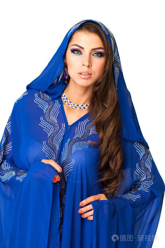 年轻的阿拉伯女人穿着蓝色长裙被孤立在白色背景上