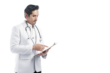 英俊的亚洲医生，穿着实验室外套，在剪贴板上写着读书笔记，站在白色背景上