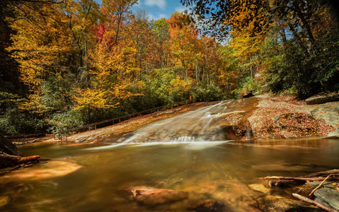 北卡罗来纳州阿巴拉契亚山脉的滑动岩石在深秋落下，带着秋色的叶子