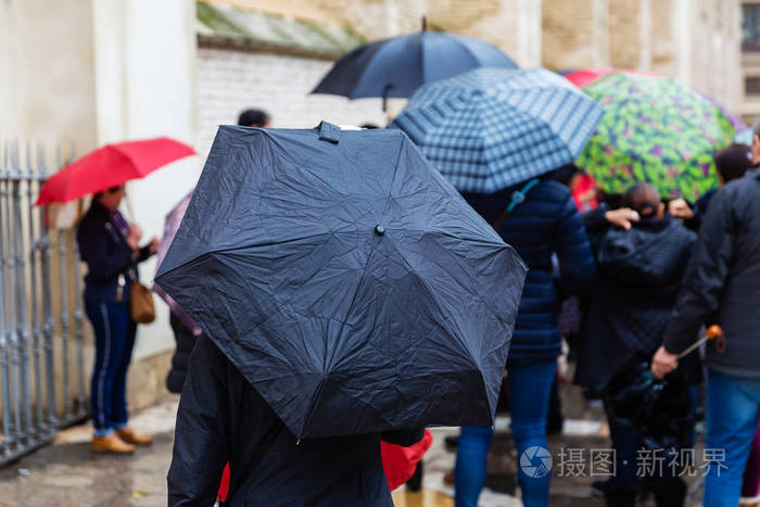 在城市里一群撑着雨伞的人在搬家