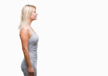 年轻漂亮的金发女人在孤立的背景下,看着侧面放松的轮廓姿势,自然的脸