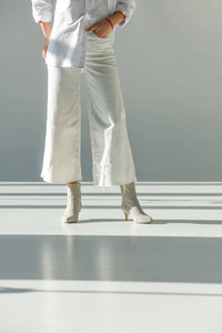 穿着时髦裤子和鞋子站在白色衣服上的女人形象