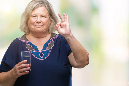 高加号白种人女人喝一杯水在隔离的背景下做OK标志用手指优秀的符号