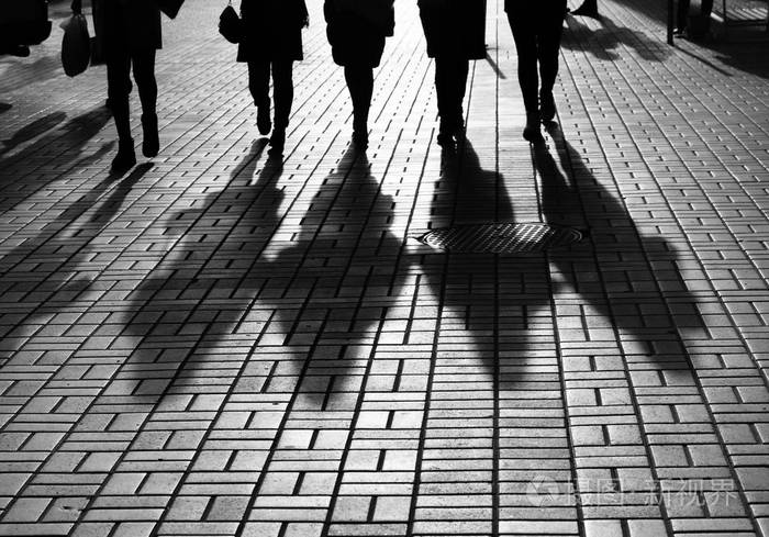 生活方式的概念城市里的光和阴影人们在大城市的街道上行走的剪影被