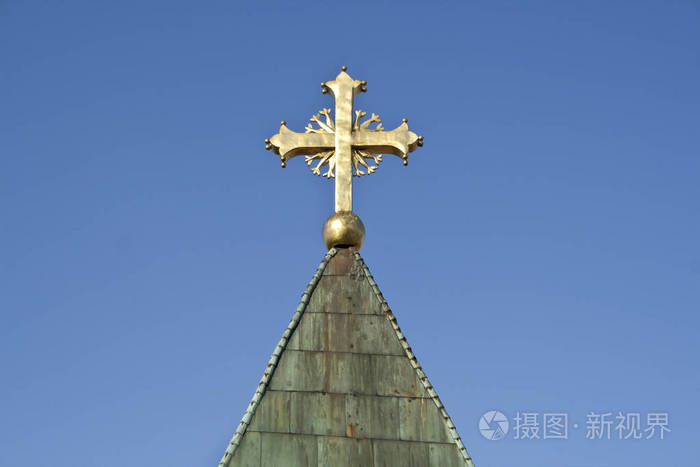 蓝天上教堂的金色十字架