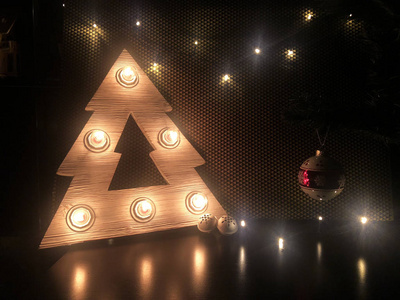 木制圣诞树, 有灯。桌子上的圣诞玩具。圣诞快乐