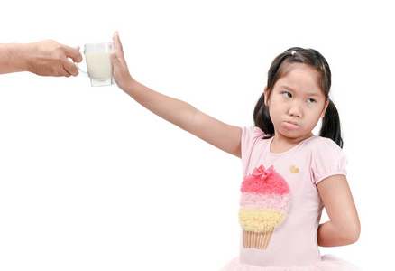 无聊的女孩，对白色背景上分离的新鲜牛奶表示厌恶，拒绝食物概念