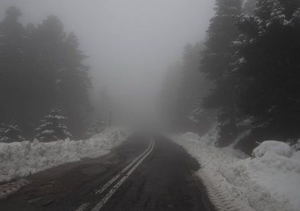 希腊埃维娅岛上的迪尔菲斯山上森林中的山路雾云和雪