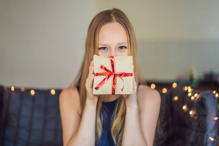 年轻女子摆着礼物，裹着红丝带的手工纸，准备圣诞礼物